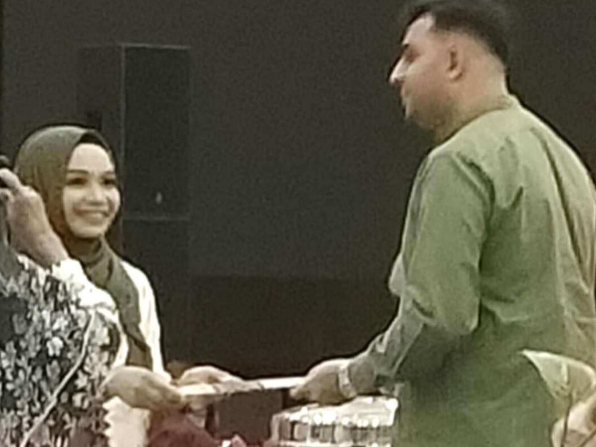 Dian Muhtadiah Hamna, M.Si. menyerahkan ijazah doktor kepada suaminya, Muhammad Awais. (Foto:MDA).